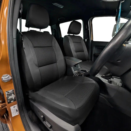 Installed front seat covers in a car: gray textured inserts with dark outer panels
