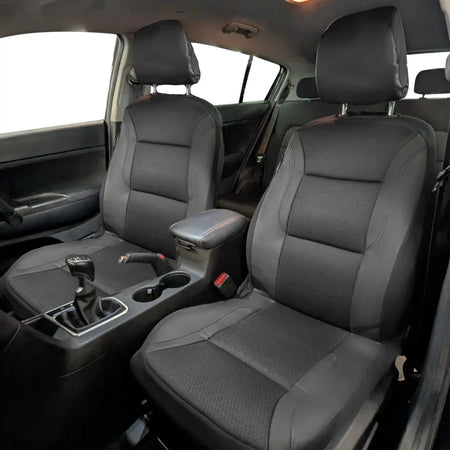 Installed front seat covers in a car, gray textured upholstery with dark trim edges