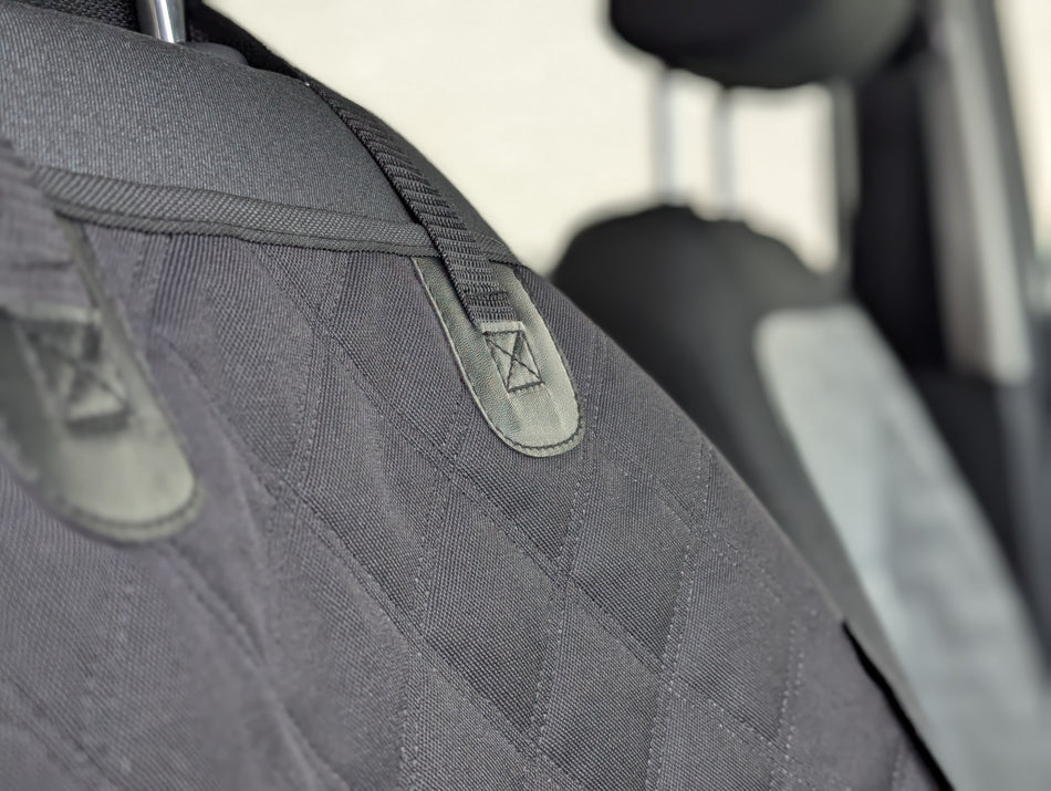 Dark gray single seat protector with quilted diamond pattern and headrest opening