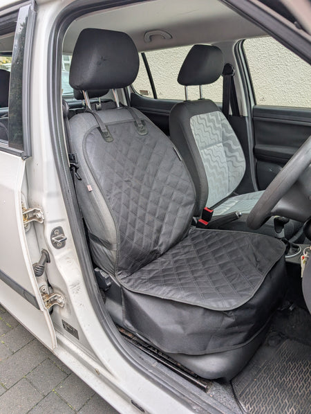 Installed single seat protector with quilted seat and backrest cover in dark gray