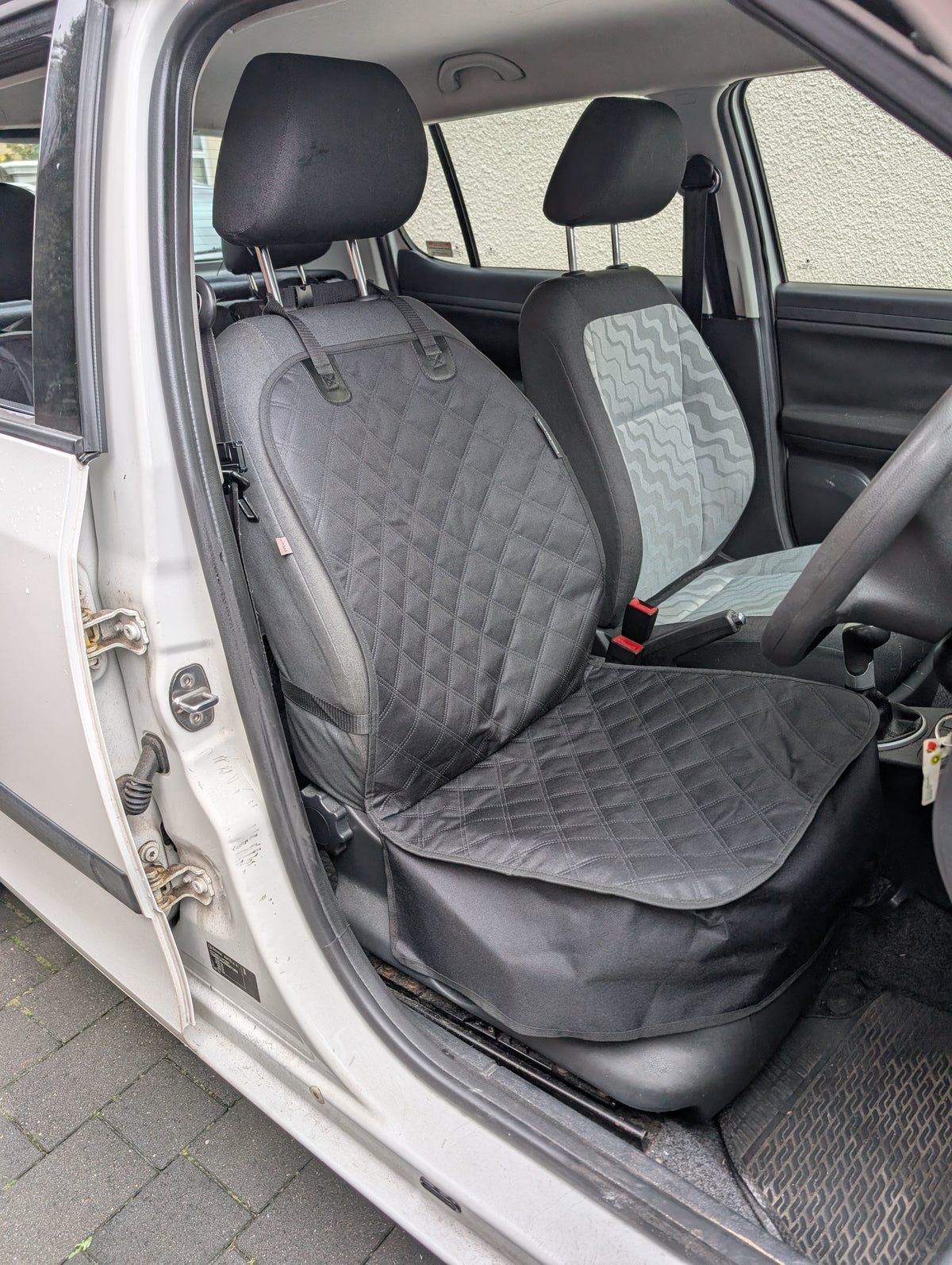 Installed single seat protector with quilted seat cushion and backrest cover, dark gray