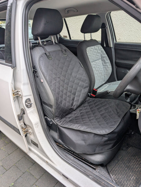 Installed single seat protector with quilted seat cushion and backrest cover, dark gray