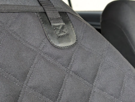 Dark gray seat protector panel with stitched webbing strap and embroidered logo patch