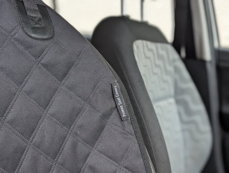 Dark gray quilted seat protector with small branded label on side seam