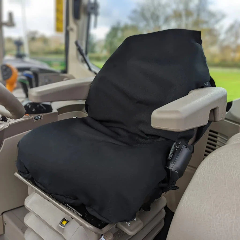 Black tractor seat cover on operator seat with armrest pad and control-side access