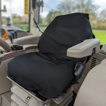 Black tractor seat cover on operator seat with armrest pad and control-side access